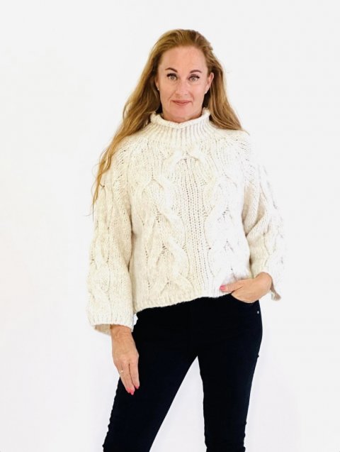 Smuk kraftig strikket, creme farvet kort bluse, glat strik p ryg og kabelstrik mnstre p rmer og foran. Str. One Size.