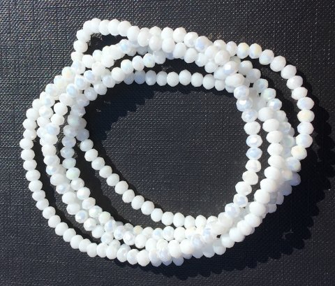 NY BILLIGERE FAST PRIS!! Hvid halskde/armbnd. Sm fine perler p elastik snor, der kan bruges til halskde eller snores 5-6 gange om hnden og bruges til smart armbnd.