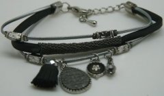 Flot sort armbånd i forskellige materialer med charms og grå bånd. Lukkes med karabinlås