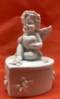 10 x 6 cm smuk engle der holder på hjerte med højre hånd øverst, sidder på låget af en hjerte æske. Lavet af polyresin materiale, fra POBRA design